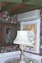 Historic interior room of New London Maritime Museum featuring vintage lamp and floral wallpaper