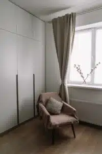 Thick heavy curtains hanging on window in minimalist room to reduce heat loss and improve home insulation during winter