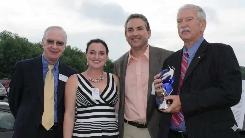 Tony Sheridan Tricia Walsh Jonathan Duncklee and Les Duncklee posing together at Duncklee Cooling and Heating 40th anniversary celebration at Stonington Connecticut headquarters June 2013