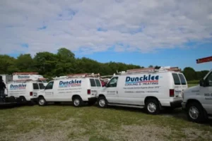 Multiple Duncklee Cooling and Heating branded fleet vans parked at Taugwonk Road business location in Stonington Connecticut