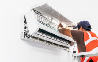 Young repairman fixing a ductless minisplit air conditioning system