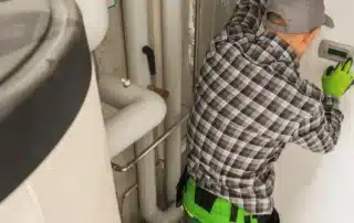 HVAC technician repairing heating system pipes and boiler components in utility room Connecticut