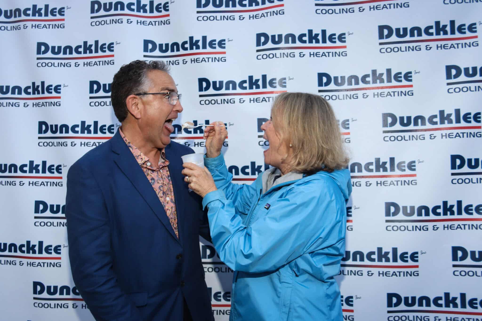 Duncklee Logo Backdrop Photo Mystic Colleagues posing for a photo in front of the Duncklee Cooling and Heating logo backdrop in Mystic, CT.